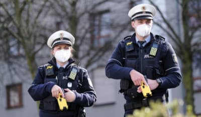 Masked police with yellow tasers